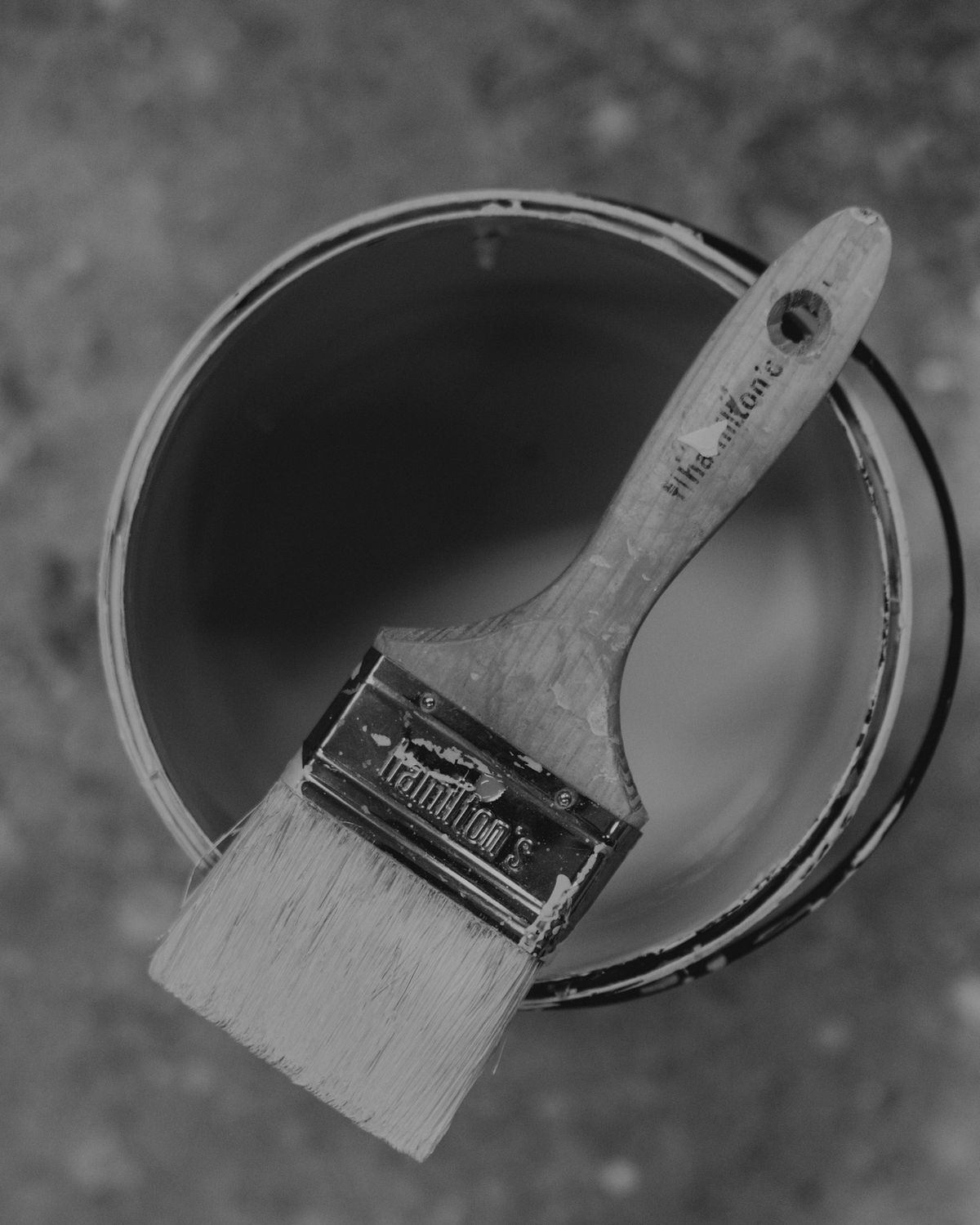 Top-down view of a brush resting on an open paint can