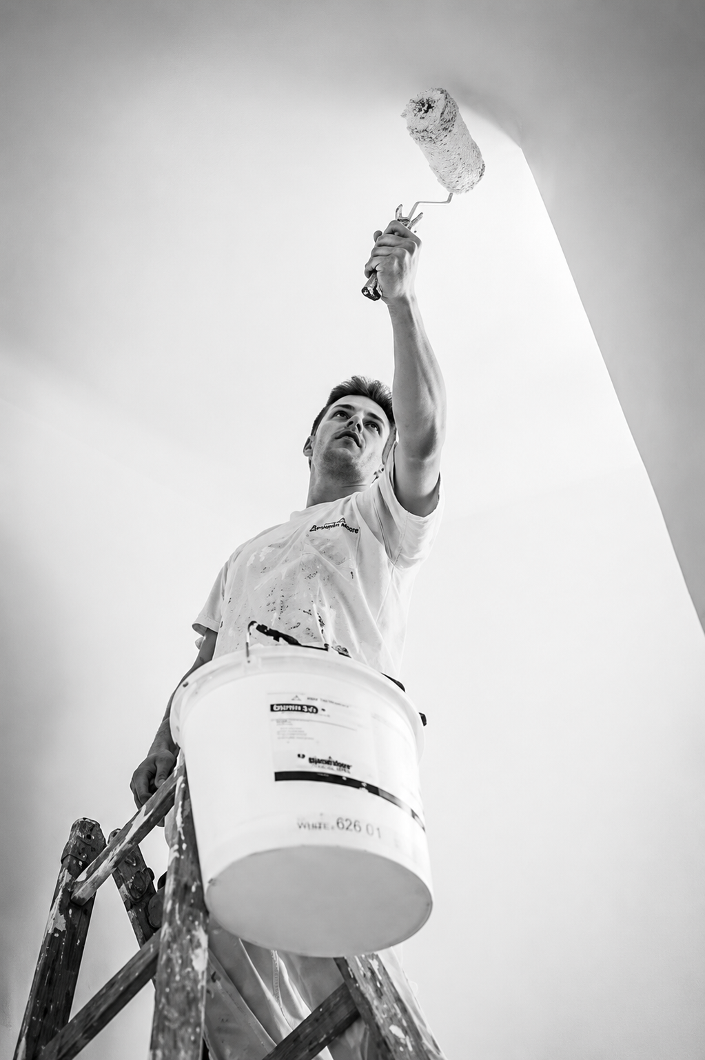 Painter reaching up from a ladder